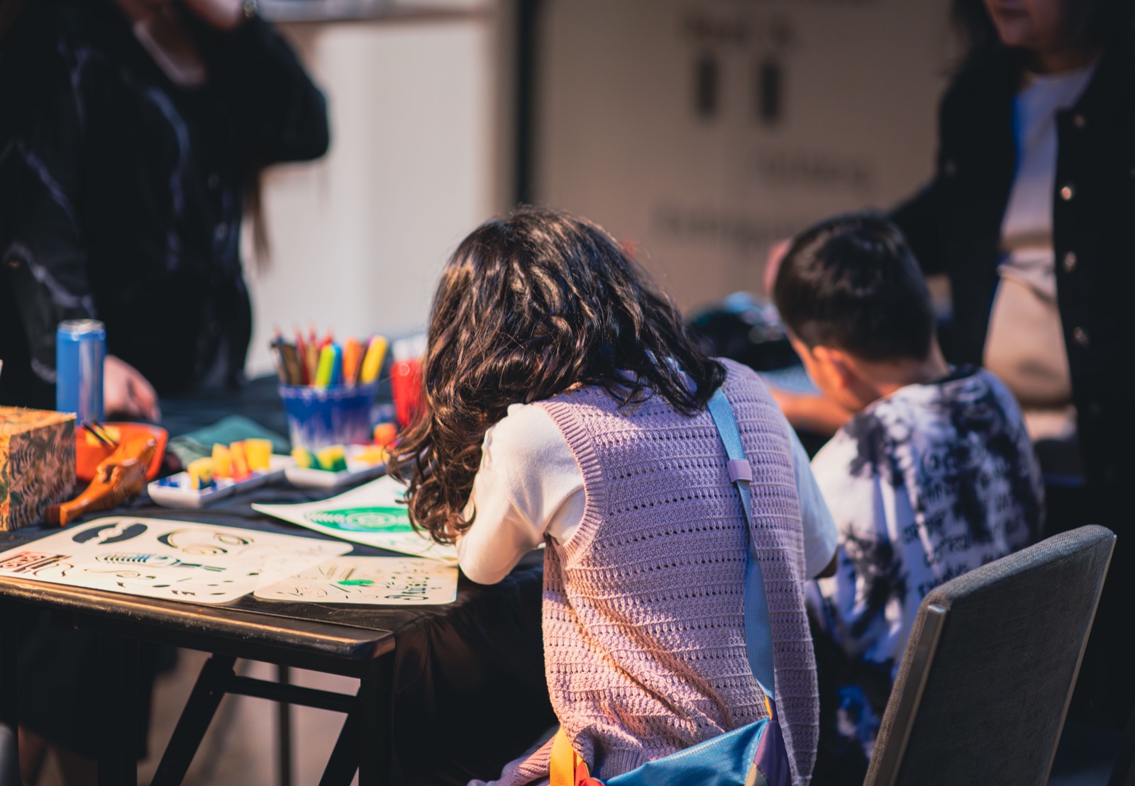 Children and adults making things together at the craft tables.