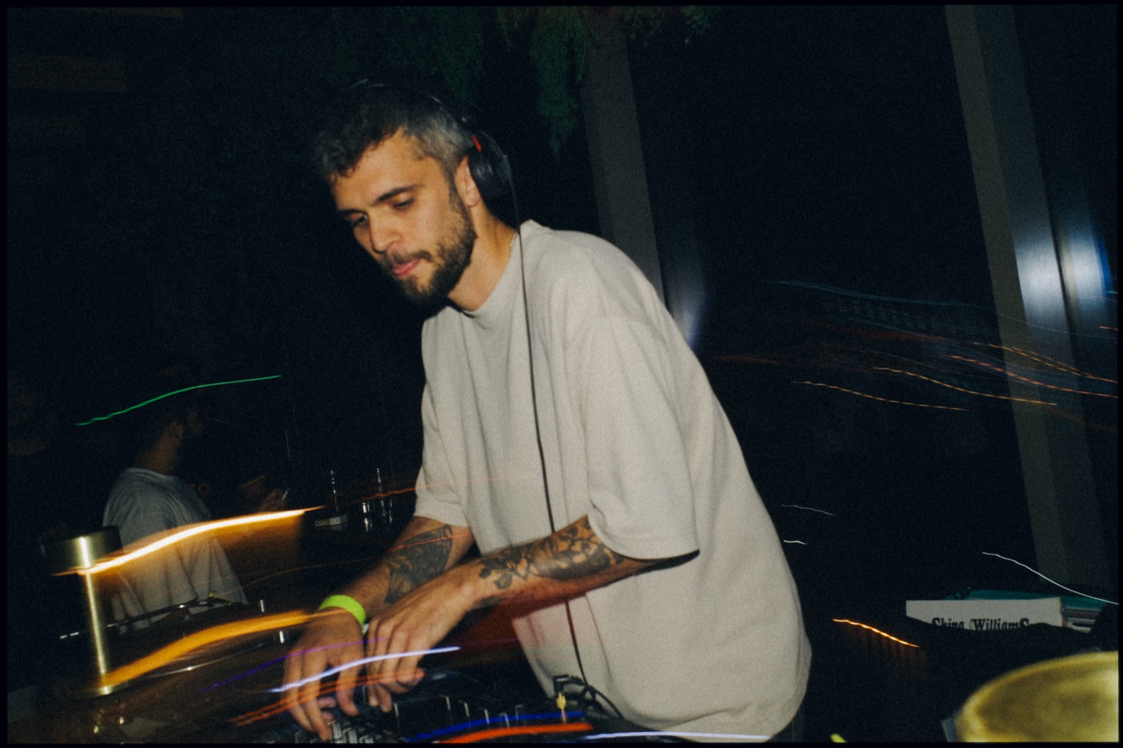 A DJ at the mixer, with light trails from a slow shutter.