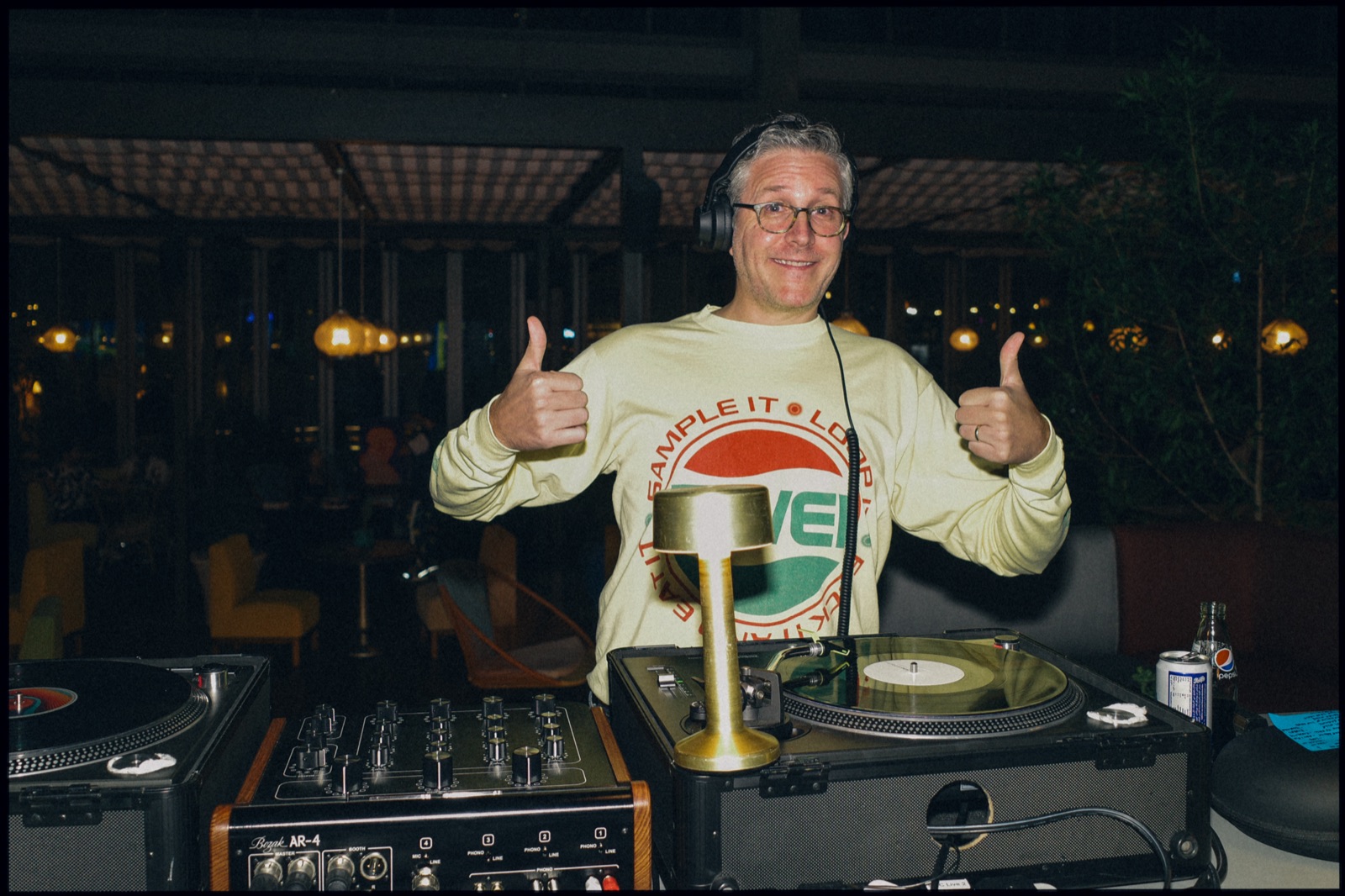 A DJ giving two thumbs up at the decks.